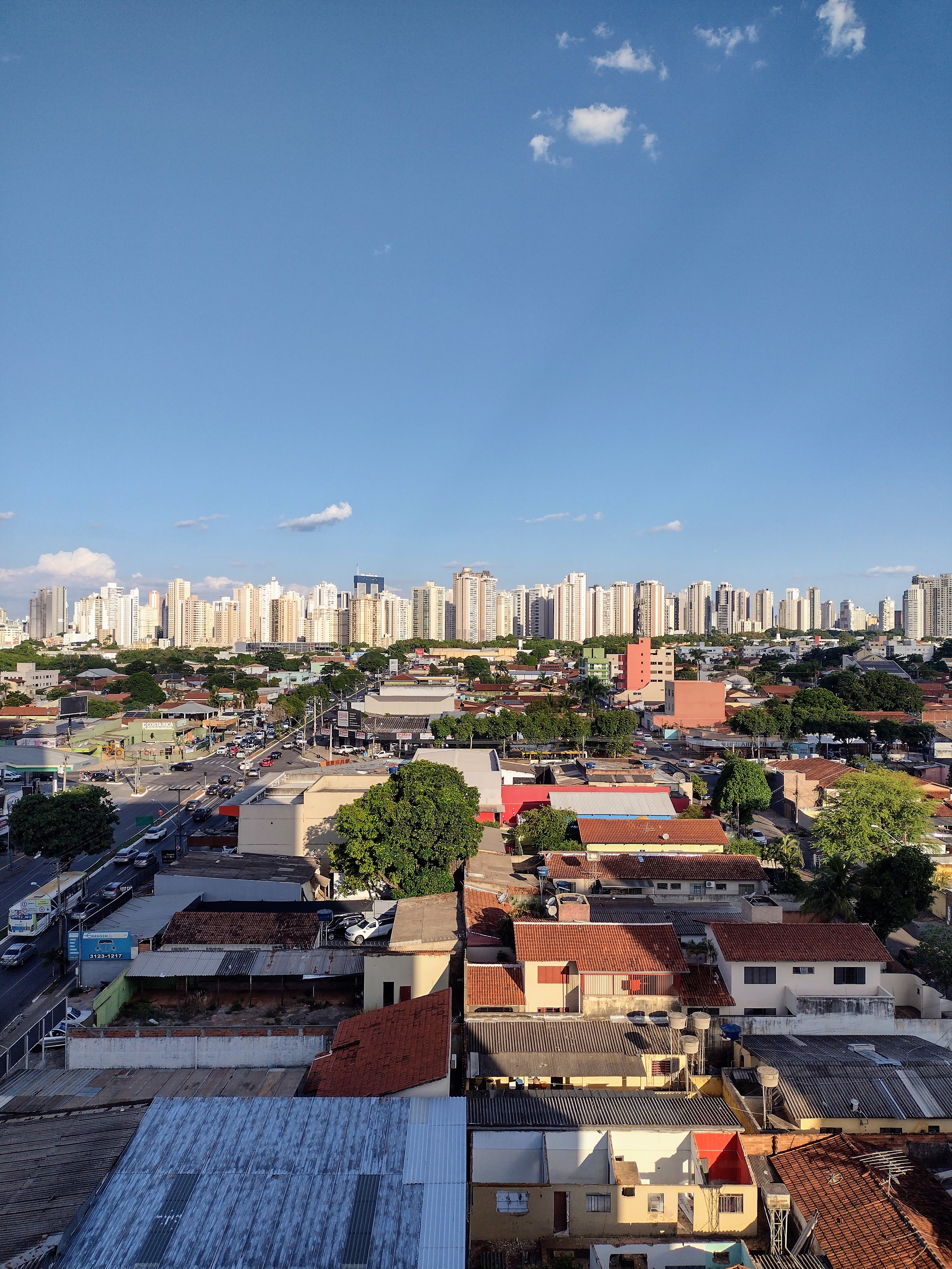 Panorama de Goiânia com casas em primeiro plano e skyline de prédios ao fundo