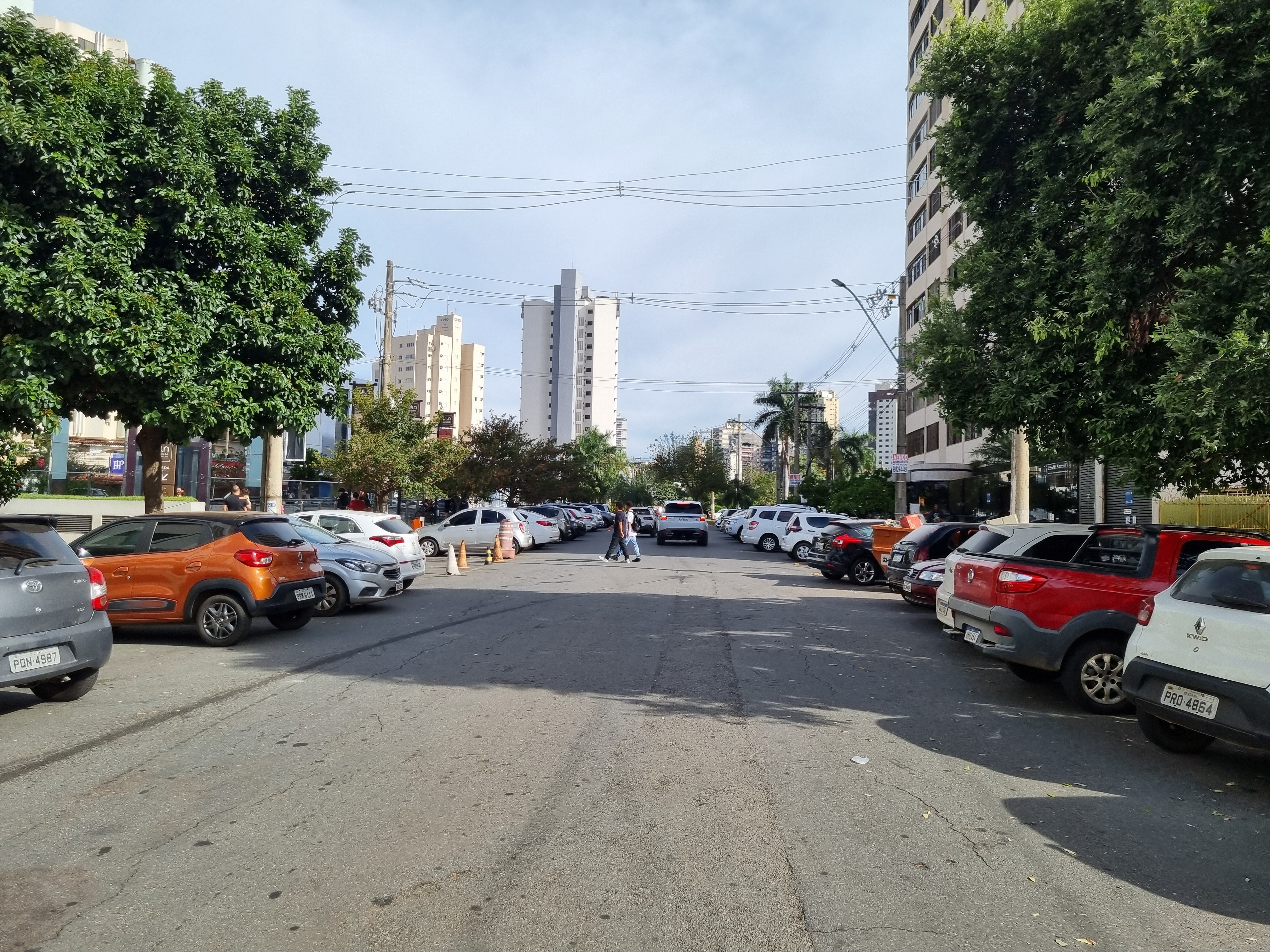 Rua arborizada no Centro de Goiânia com prédios residenciais ao fundo